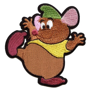 May include: Embroidered patch of a brown cartoon mouse wearing a green hat and a yellow shirt. The mouse is smiling and has pink ears and a pink nose. The patch is perfect for adding a touch of whimsy to clothing, bags, or other accessories.