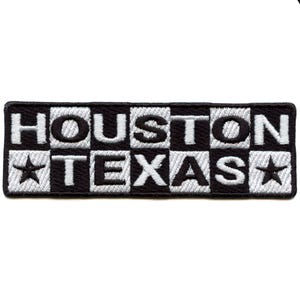 Puede incluir: Un parche rectangular bordado en blanco y negro con las palabras "HOUSTON TEXAS" en letras blancas. El parche tiene un diseño de tablero de ajedrez y dos estrellas blancas.