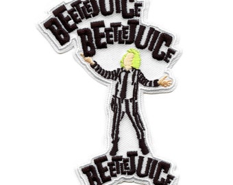 May include: An embroidered patch featuring a cartoon character in a black and white striped suit with green hair, holding up the word "BEETLEJUICE" in black lettering. The word "BEETLEJUICE" is repeated three times on the patch.