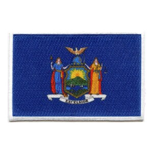 May include: A blue embroidered patch with the state seal of New York. The seal features a shield with a sun rising over a mountain range, surrounded by a wreath of leaves and a ribbon with the word "Excelsior".
