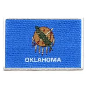 Könnte beinhalten: Ein blauer gestickter Aufnäher mit dem Staatssiegel von Oklahoma, das einen Pfeil, eine Friedenspfeife und einen Stern zeigt. Der Text "OKLAHOMA" ist in Weiß unter dem Siegel geschrieben.