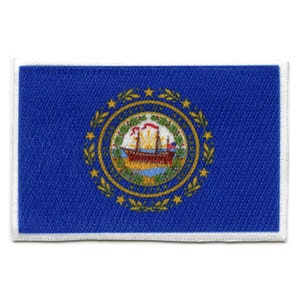 May include: A blue patch with a white border featuring the state seal of New Hampshire. The seal depicts a ship sailing on a body of water with a sun rising behind it. The seal is surrounded by a wreath of green leaves and gold stars.