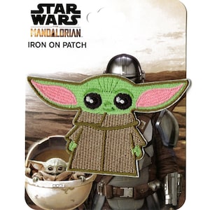 Könnte beinhalten: Grün-rosa gestickter Bügel-Patch mit einer Comicfigur aus der Star Wars: The Mandalorian-Serie. Der Patch trägt die Aufschrift "Star Wars The Mandalorian Iron On Patch".