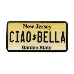 May include: A yellow and black New Jersey license plate patch with the text "CIAO BELLA" and the state motto "Garden State".