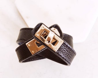 Svart armband i konstläder med silverfärgad spänne