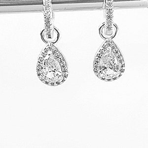 Pu&ograve; includere: Un paio di orecchini a cerchio d'argento con ciondoli a goccia di cristallo trasparente a forma di pera.