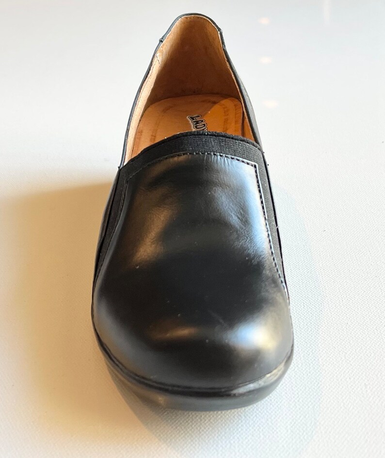 Peut inclure: Chaussures &agrave; enfiler en cuir noir avec une bande &eacute;lastique noire sur le dessus. Les chaussures ont un int&eacute;rieur en cuir marron et une semelle en caoutchouc noir.