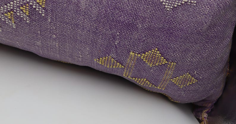Puede incluir: Coj&iacute;n de decoraci&oacute;n morado y amarillo con un dise&ntilde;o geom&eacute;trico.