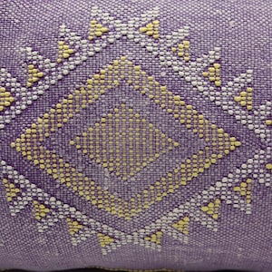 Puede incluir: Almohada morada con un patr&oacute;n geom&eacute;trico amarillo y blanco.