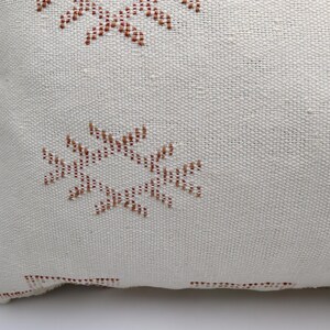 May include: White throw pillow with a brown and yellow geometric pattern.
