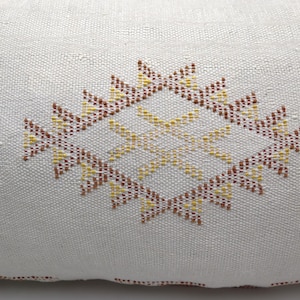 May include: White pillow with a brown and yellow geometric pattern embroidered on the front.