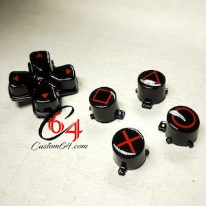May include: A set of black and red PlayStation controller buttons. The buttons feature the standard PlayStation symbols: triangle, circle, cross, square, and the directional pad.
