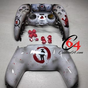 Puede incluir: Un mando Xbox personalizado blanco y rojo con el tema Ghost of Tsushima. El mando está desmontado y colocado sobre una superficie blanca. El mando presenta un círculo rojo y blanco con un guerrero samurái en el centro. El mando también presenta un logotipo rojo y blanco con las palabras "Ghost of Tsushima" en él.