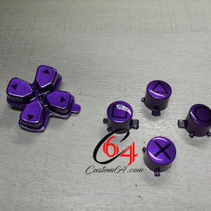 May include: Purple PlayStation controller face buttons with black symbols. The buttons include the directional pad, square, circle, triangle, and X.