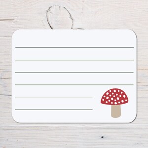 May include: A white card with lined paper and a red and white mushroom illustration. The mushroom has white spots on the red cap.