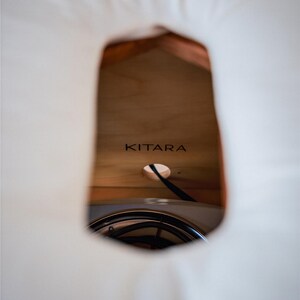 a close-up view of a wooden surface with the word "KITARA" written on it.