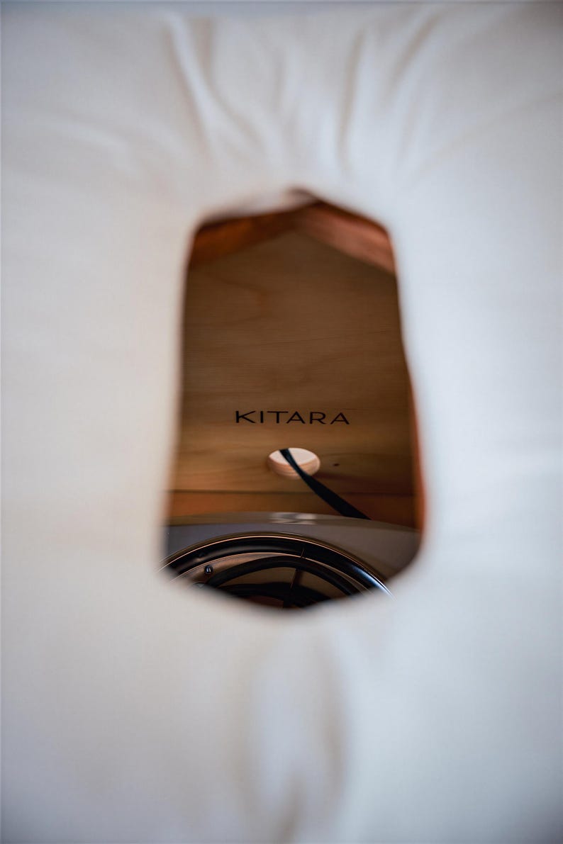 a close-up view of a wooden surface with the word "KITARA" written on it.