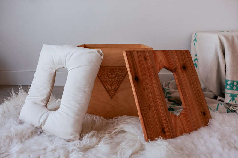 a wooden box with a cutout on the lid, placed on a white furry surface.