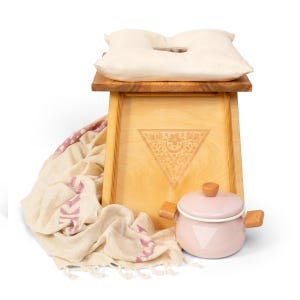 a wooden stool with a pillow and a pot