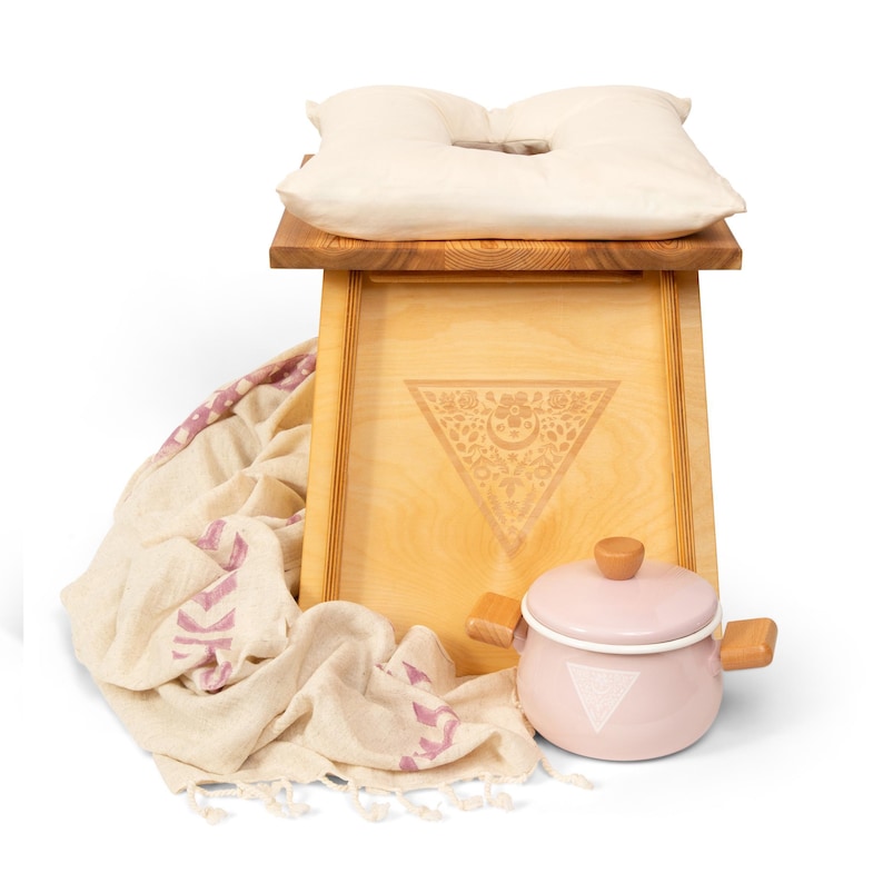 a wooden stool with a pillow and a pot