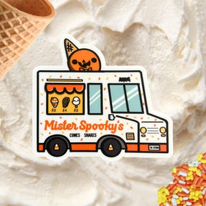 May include: A white sticker of an ice cream truck with orange and black accents. The truck has the text "Mister Spooky's" and sells cones and shakes. A jack-o'-lantern is on top of the truck. The sticker is on a white, creamy background.