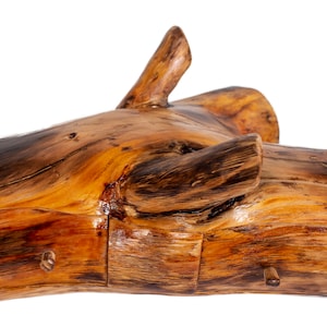 Puede incluir: Una caja de madera tallada en un tronco de árbol con dos cajones. La caja es de color marrón natural con acentos marrón oscuro.