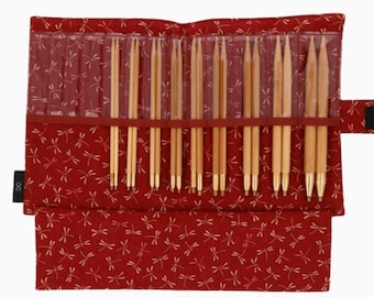 May include: A red fabric case with a dragonfly pattern holds a set of bamboo knitting needles. The needles are arranged in rows and are all the same length. The case has a zipper closure and a small black tag with the number 8 on it.