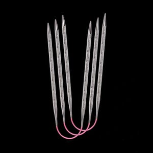 Peut inclure: Un ensemble de six aiguilles à tricoter argentées avec des pointes, reliées par un câble rose, sur fond noir. Les aiguilles présentent un motif texturé sur leurs tiges et sont disposées en forme de U.