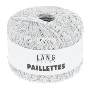 May include: A ball of silver yarn with embedded sequins. The yarn is wrapped around itself, forming a cylindrical shape. The label on the yarn reads "LANG YARNS PAILLETTES".