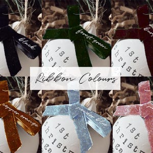 May include: A collection of white Christmas ornaments with various colored ribbons, including black, forest green, burgundy red, copper orange, powder blue, and pastel pink. Each ornament has the text "1st Christmas" printed on it. The image also includes the text "Ribbon Colours".
