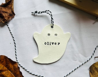 May include: White ceramic ghost ornament with black string and the name "oliver" written on it.