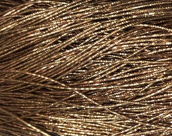 May include: A bundle of metallic gold cord, a type of trim used for embellishing clothing and accessories.