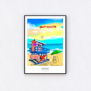 May include: A framed art print depicting a vibrant beach scene in Miami, USA. The artwork features a lifeguard stand with red, white, and blue stripes and stars, a green umbrella, and a biplane with a banner. The text "MIAMI U.S.A." is at the bottom.