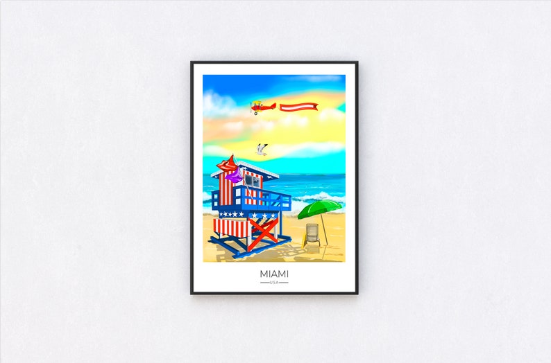 May include: A framed art print depicting a vibrant beach scene in Miami, USA. The artwork features a lifeguard stand with red, white, and blue stripes and stars, a green umbrella, and a biplane with a banner. The text "MIAMI U.S.A." is at the bottom.