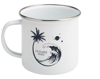 May include: White enamel mug with a silver rim and handle. The mug features a black graphic of a palm tree, a wave, and a planet, with the words "EXPLORE MORE".