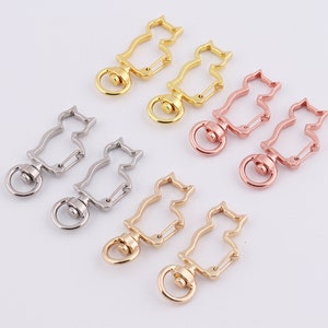 May include: Six silver, gold, and rose gold cat-shaped swivel clasps with a spring-loaded gate. The clasps are perfect for attaching to keychains, bags, or other accessories.