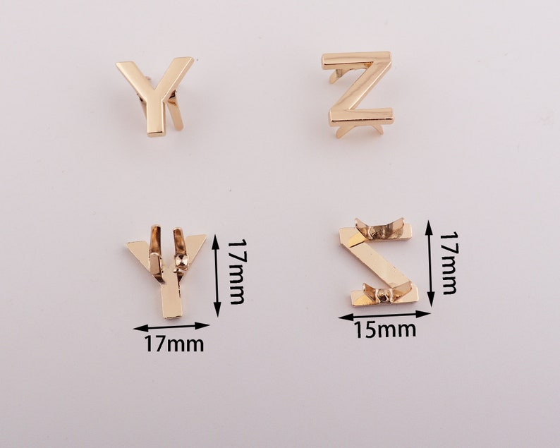 May include: Gold metal letter charms in the shape of the letters Y, Z, and S. The charms are 1.7 inches tall and 1.7 inches wide. The S charm is 1.5 inches wide.