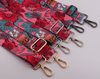 Può includere: Cinque cinturini in tessuto con motivo floreale rosa e verde con fibbie metalliche di diversi colori. Le fibbie sono dorate, argentate e nere.