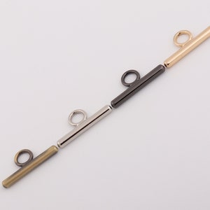 May include: Three metal bar toggles with a loop at one end. The toggles are gold, silver, and antique brass.