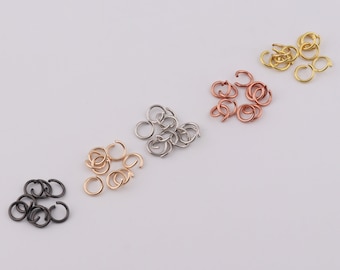 May include: Assortment of jump rings in four different colors: black, silver, rose gold, and gold. The jump rings are arranged in rows on a white background.