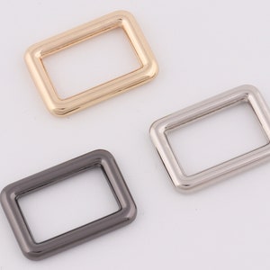 May include: Three metal D-rings in gold, silver, and black.