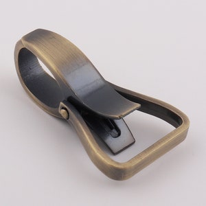 May include: Antique brass swivel trigger snap hook. The hook is open and ready to be attached to a strap, leash, or other item.