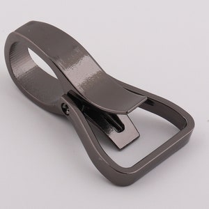 May include: A gunmetal gray metal swivel hook with a rectangular loop. The hook is designed to attach to a belt loop or other similar item.