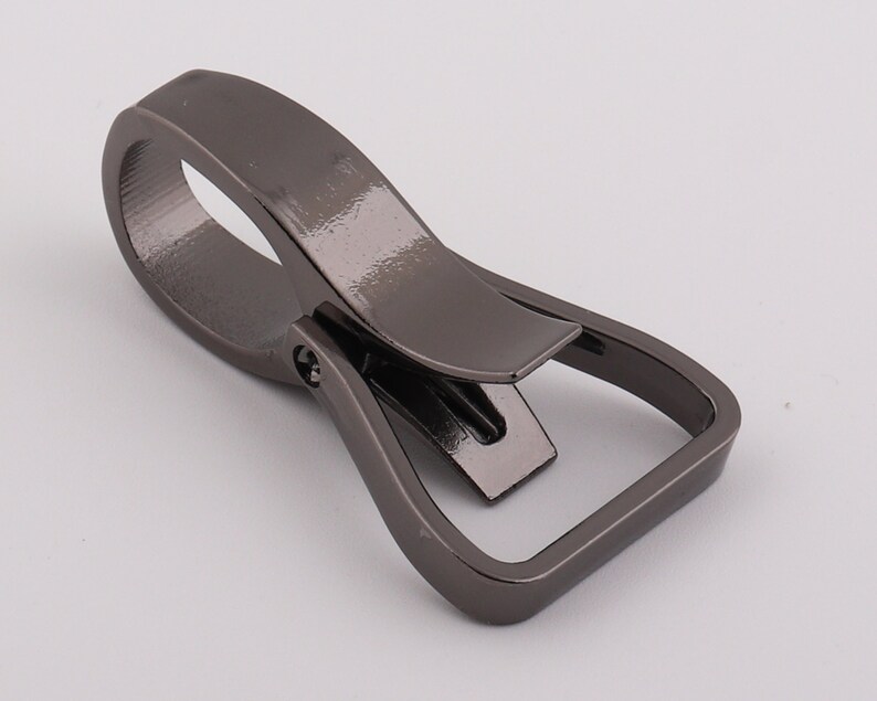 May include: A gunmetal gray metal swivel hook with a rectangular loop. The hook is designed to attach to a belt loop or other similar item.