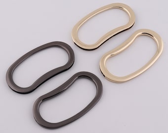 May include: Two pairs of metal bag handles. One pair is gold and the other is black.