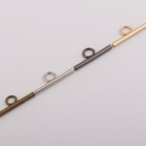 May include: Four metal bar toggles with a loop at one end. The toggles are in gold, silver, black, and bronze.