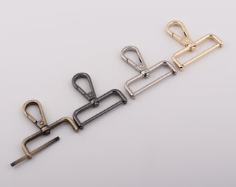 May include: Four metal swivel clasps in different finishes: gold, silver, black, and antique brass. Each clasp has a rectangular frame and a hook.