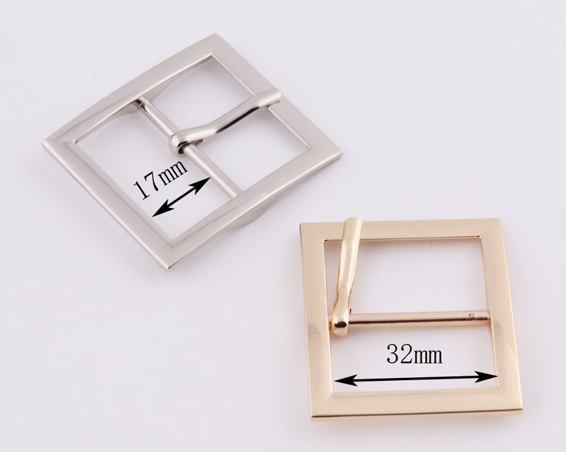 May include: Two metal belt buckles, one silver and one gold. The silver buckle measures 1.7 inches wide and the gold buckle measures 1.25 inches wide.