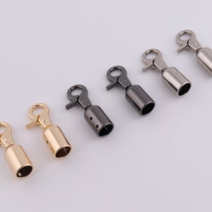 May include: Five metal swivel clasps in different finishes: gold, silver, and black. The clasps are designed for attaching to bags, purses, or other accessories.