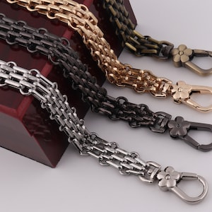 May include: Four different chain styles with flower-shaped clasps. The chains are silver, gold, black, and antique gold.
